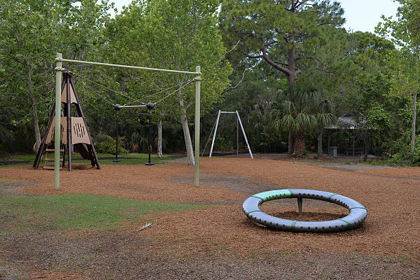 istock Rustic Playground Area in a Lush Green Park with Picnic Table and Bench 2213134036