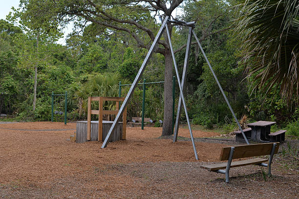 istock Rustic Playground Area in a Lush Green Park with Picnic Table and Bench 2213134037