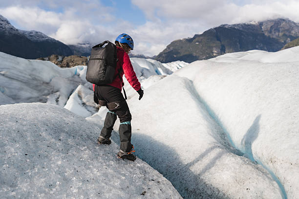 istock Female hiker walking on glacier with crampons and backpack 2213135252