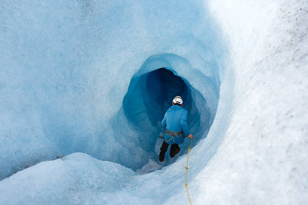 istock Mountain guide exploring a glacial cave in the ice 2213135613