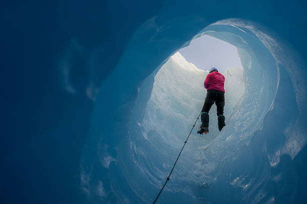 istock Mountaineer ascending a moulin inside a glacier with crampons and ice axe 2213135649