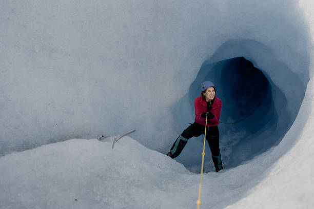 istock Female explorer climbing out of a glacier crevasse using rope 2213136300