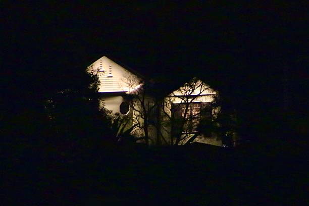 istock single house in darkness with its porch lights on 2213136950