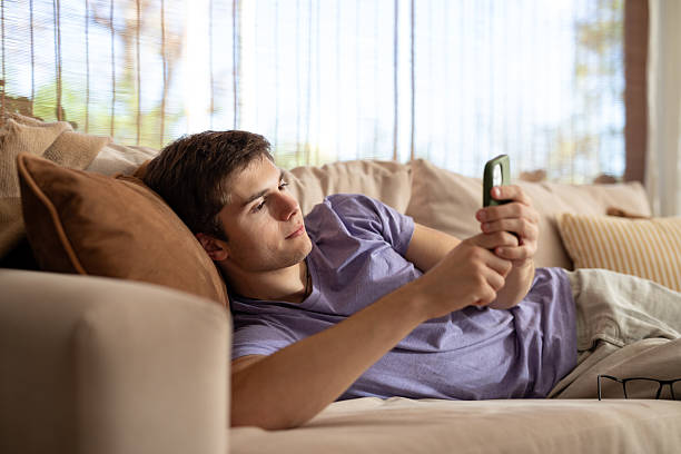 istock Young man using his smartphone in the living room 2213138069