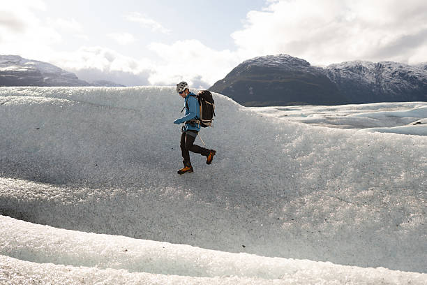 istock Mountaineer walking on glacier with crampons and backpack 2213138952