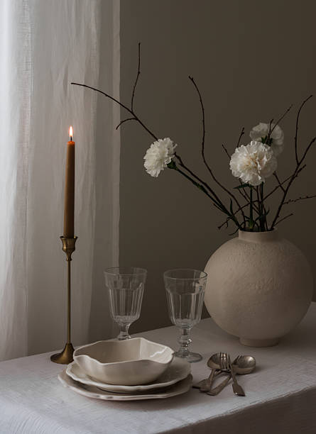 istock Empty dishes, a bouquet of carnations in a ceramic vase, a candle, cutlery - minimalistic setting 2213139121
