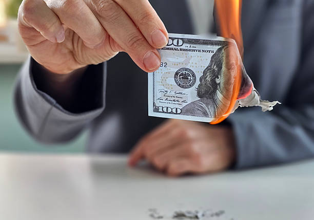 istock Burning a hundred-dollar bill to express discontent with financial systems and personal wealth 2213142639