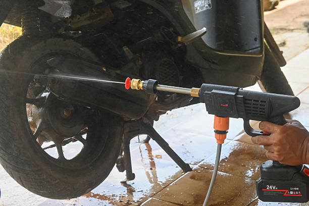 istock A man's hand is washing a motorbike using a portable jet cleaner. 2213143337