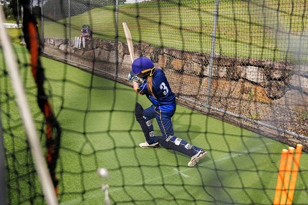 istock Young female cricketer at training practicing her batting in the nets 2213143557