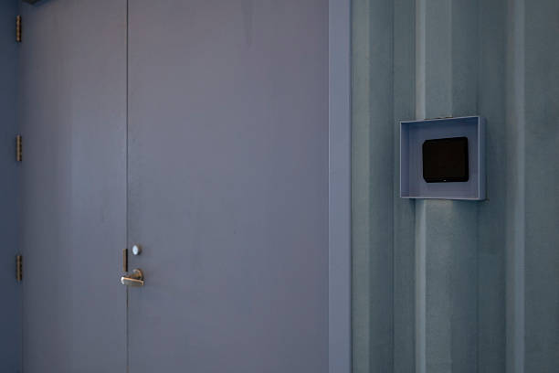 Close-up on the doorknob of a plain old gray metal door.
