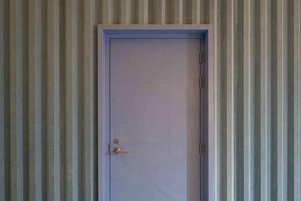 A simple industrial setting featuring a closed door on a corrugated metal wall, reflecting a minimalist aesthetic suitable for modern design concepts.