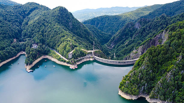 istock Massive Concrete Dam Surrounded by Forested Hills and Calm Blue Waters 2213148846