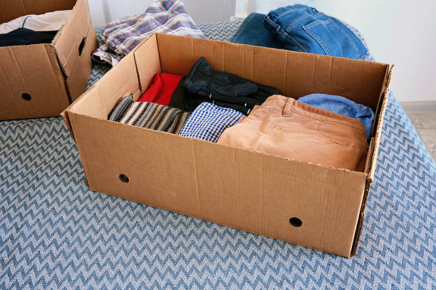 istock Several cardboard boxes for donations with things. Help for the poor and needy people. 2213163316