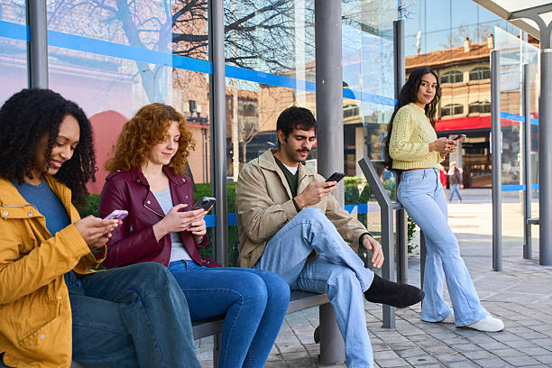 istock Young people using smartphones at bus stop 2213163941