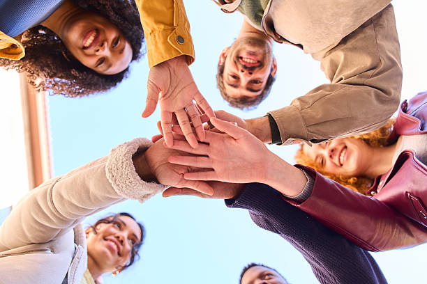 Group of students joining hands in teamwork and collaboration