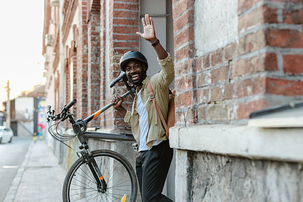 istock Man with bicycle waving on urban street with a cheerful expression 2213164590