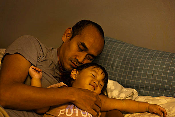 istock Father And Son Sleep Together On The Bed 2213164687