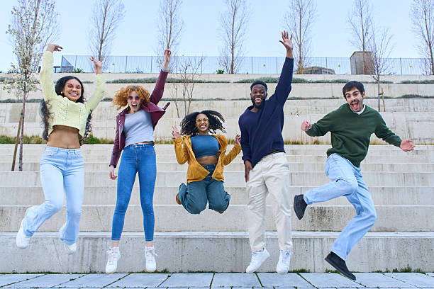 istock Happy young students jumping together celebrating success in university campus 2213166350