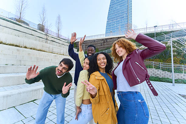 istock Happy young students waving and smiling in university campus 2213166444