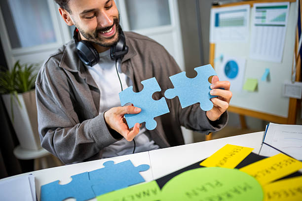 istock A business man at home, carefully assembling a puzzle. 2213167552