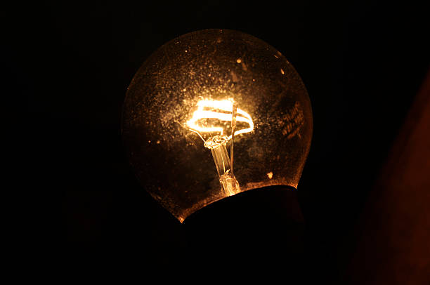 istock An old vintage light bulb glows with a brownish-yellow light through its filament. It gets very hot when lit, giving a warm, classic feel. 2213167795
