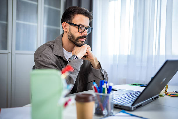 istock Young man working remotely from home on his laptop. 2213168646