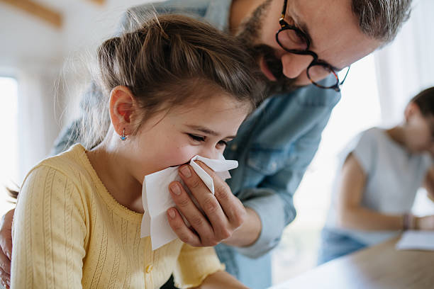 istock Father helping his daughter blow congested nose. 2213169420