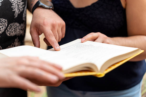 istock Friends reading and discussing a book together 2213169758