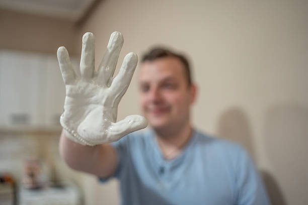 Blurry background image of a man showcasing his hand, holding a detailed resin cast, embodying craftsmanship and creativity. Perfect for expressions of art, DIY, and personal projects.