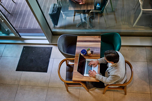 istock Businessman working on laptop in a cafe, seen from above 2213172492