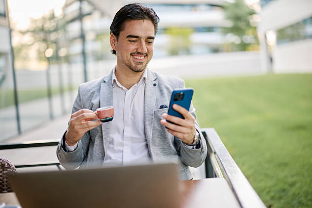 istock Businessman drinking coffee and using smartphone in outdoor cafe 2213172543