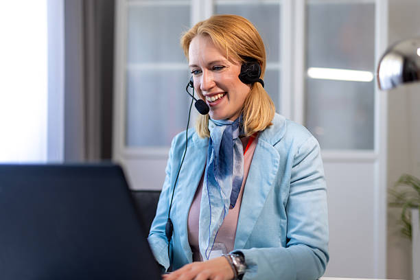 istock Remote work: woman using a laptop and headset for virtual meetings. 2213174077