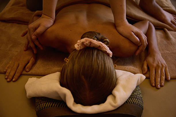 Senior woman lying on front on a massage table while enjoying a massage.