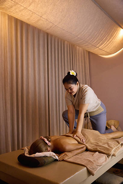 A relaxing spa session featuring a skilled therapist performing a soothing back massage on a serene individual in a tranquil, softly lit environment, emphasizing wellness, comfort, and rejuvenation.