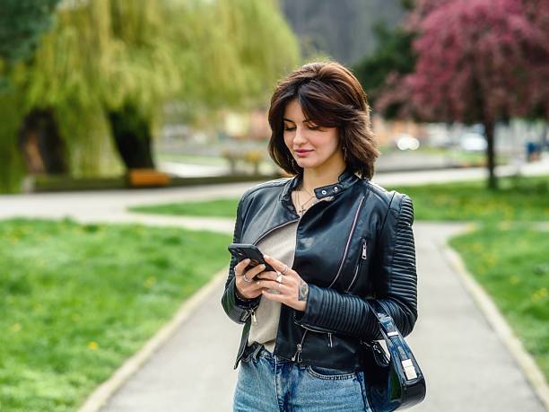 A young woman using a smartphone on the park