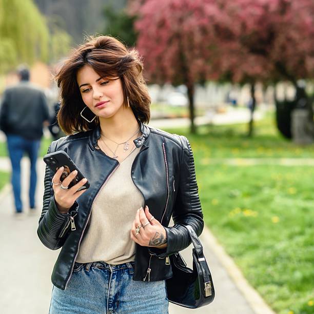 A young woman using a smartphone on the park