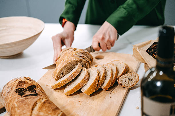 istock Slicing Fresh Artisan Bread on Wooden Board 2213191666