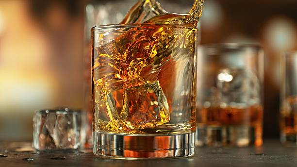 istock An ice cube falls into a glass of poured whiskey causing a splash. 2213192372