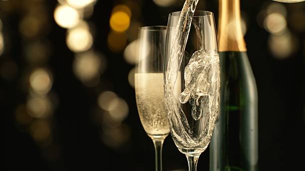 istock Pouring Champagne Wine into Glass, Isolated on Black Background. 2213195111