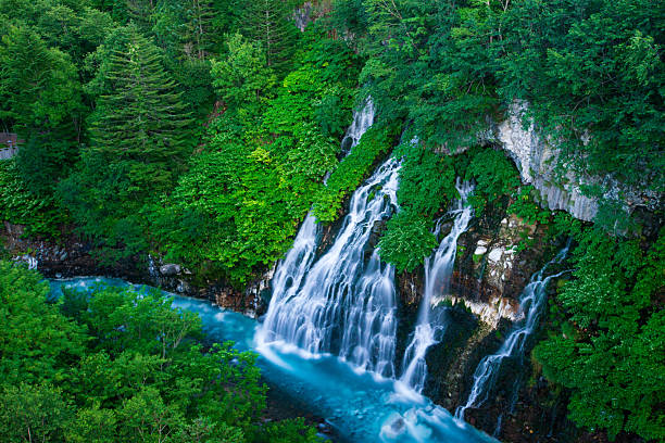 Shirahige Waterfall with deep cobalt blue hue Biei river flow beneath, Biei, Kamikawa Subprefecture, Hokkaido, Japan