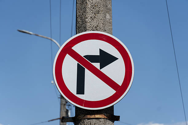 istock Regulatory Traffic Sign Indicating No Right Turn Mounted on a Gray Post Against a Clear Blue Sky, Signifying Restriction 2213201965