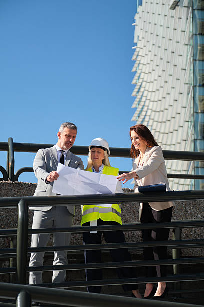 istock Architects and engineer reviewing blueprints on construction site near modern building 2213205713