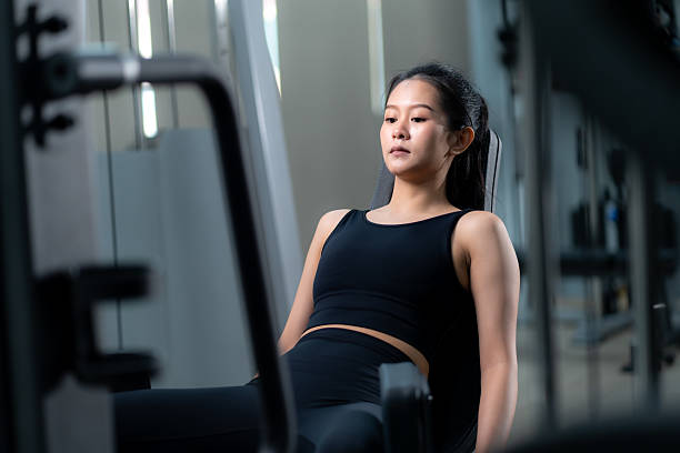 istock Asian woman training on leg press machine at gym. 2213208223