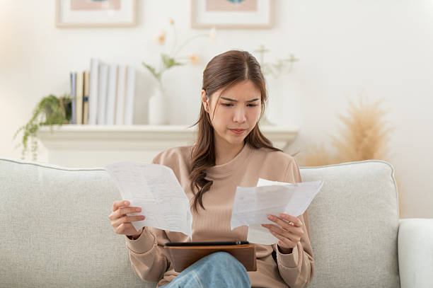 istock Asian woman feeling unhappy after looking at the bill feels stressed having financial problem, check finances, experiencing lack of money pay for loan, huge taxes, utility rates, get eviction notice 2213212300