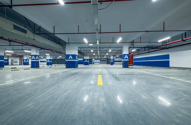 istock Empty modern underground parking garage interior with concrete floor pillars and ceiling lights. 2213217748