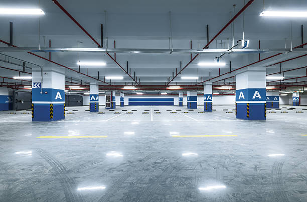 istock Spacious empty modern underground parking lot garage interior with concrete floor blue pillars and bright lighting. 2213217783