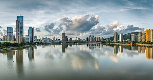 istock Panoramic view of the Macau cityscape skyline reflecting in calm water under dramatic cloudy sky, China. 2213217981