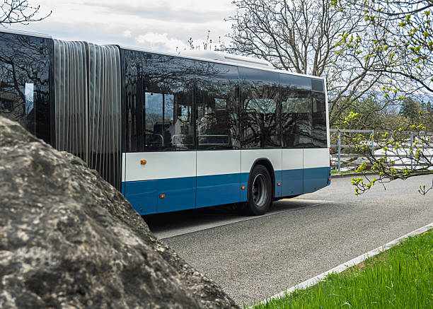 istock Articulated Bus on Road with Trees and Rock 2213219220
