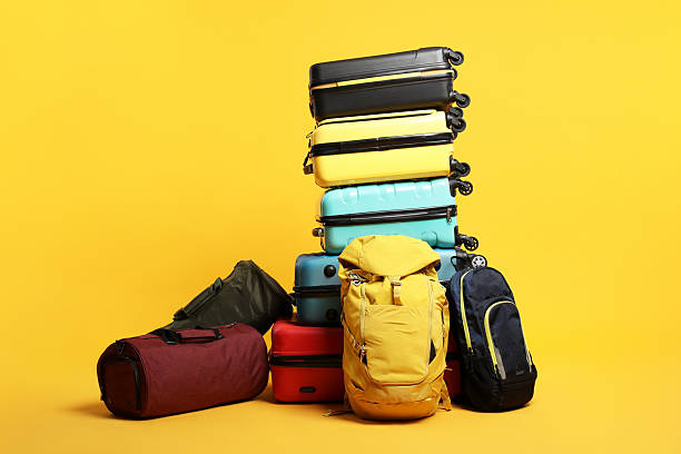 istock Stack of colorful suitcases, backpacks and bags on orange background 2213223271