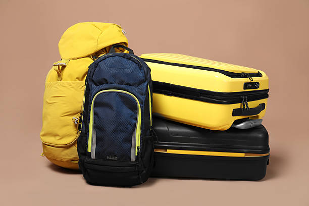 istock Colorful suitcases and backpacks on beige background 2213223298